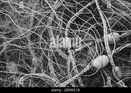 Asciugando rete da pesca con galleggianti. Foto di sfondo in bianco e nero Foto Stock