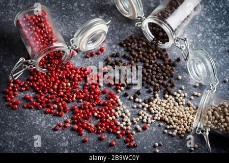 Peperoni rosa, bianco e nero in vasetti di vetro. Foto Stock