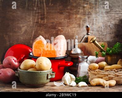 Varietà di patate biologiche crude non cotte: Patate rosse, bianche, dolci e con le dita su sfondo di legno. Foto Stock