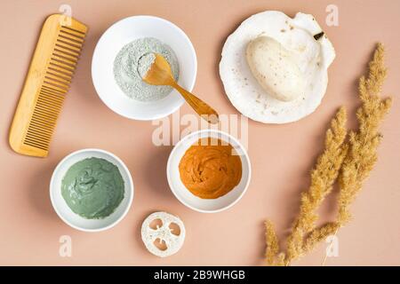 Maschere in argilla per il viso fatte in casa e prodotti cosmetici naturali biologici SPA su fondo pesca. Cura della pelle del viso e concetto di trattamento di bellezza. Disposizione piatta, superiore v Foto Stock