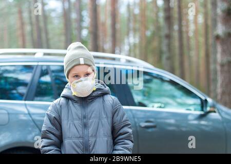 Bambino che indossa maschera facciale protettiva per l'inquinamento o corona virus.caucasico 7 anni, bambino che indossa maschera di protezione. Foto Stock