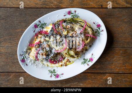 Cavolo ispi alla griglia, condimento Caesar, parmigiano e nocciole Foto Stock