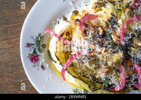 Cavolo ispi alla griglia, condimento Caesar, parmigiano e nocciole Foto Stock