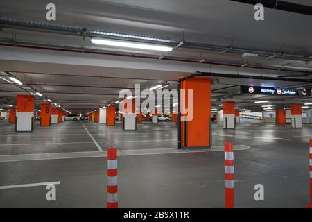 Dubai Emirati Arabi Uniti Dicembre 2019 Parcheggio sotterraneo quasi vuoto. Garage vuoto nel seminterrato dell'edificio degli uffici. Pavimenti monolitici in cemento armato Foto Stock