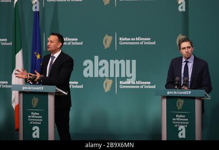 Taoiseach Leo Varadkar (a sinistra) e Ministro della Sanità Simon Harris durante il lancio di un opuscolo informativo pubblico sul coronavirus negli edifici governativi di Dublino. Foto Stock