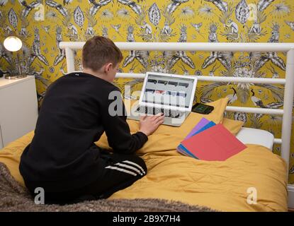 Ragazzo lavora a casa a scuola grazie a COVID19 Foto Stock