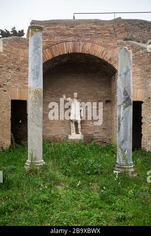 Roma. Italia. Ostia Antica. Resti della Schola di Traiano (Schola Traianea / sede della gilda di Traiano). Statua in pietra di Traiano in sala E4 (origina Foto Stock