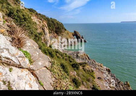 Arco di mare conosciuto come London Bridge sulle scogliere intorno a Torquay, con vista su Torbay oltre. Torquay, Devon, Regno Unito. Marzo 2018. Foto Stock