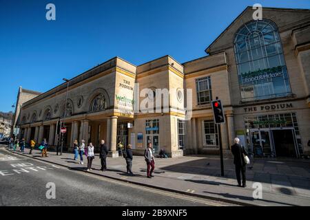 La gente si accoda fuori da un supermercato Waitrose a Bath, Somerset, dopo che il governo britannico ha annunciato severe restrizioni per cercare di controllare Coronavirus. Foto Stock