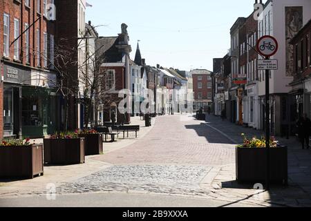 Chichester, Regno Unito. 25 Marzo 2020. Chichester, West Sussex, UK - la High Street è vuota e deserta dopo il blocco dei primi ministri Coronavirus (Covid-19). Le uniche persone sono in coda per la farmacia Boots. Mercoledì 25 Marzo 2020 credito: Sam Stephenson/Alamy Live News Foto Stock