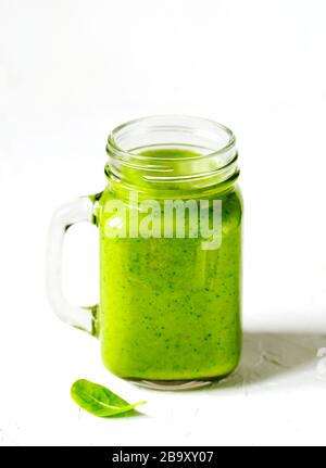 Spinaci verdi, mele e avocado Smoothie in vasi di muratura. Mangiare vegano sano. Foto Stock