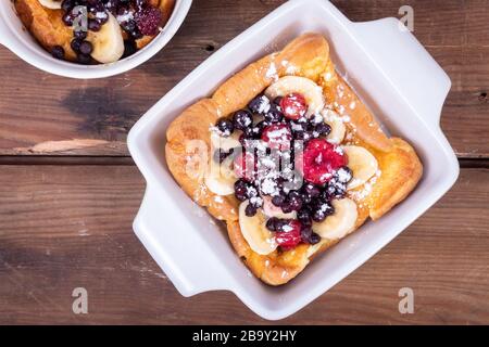 Pancake tedesco olandese sormontato con frutti di mirtilli e banana colazione al tavolo Foto Stock