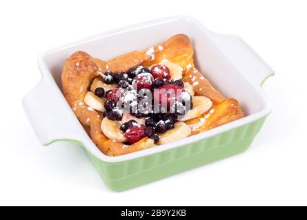 Pancake tedesco olandese sormontato con frutti di mirtilli e colazione a base di banana su sfondo bianco Foto Stock