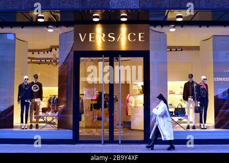 Foto esterna del designer italiano "Versace" a Düsseldorf. Giovane donna che cammina vicino. Foto Stock