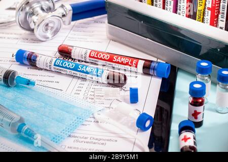 Diversi campioni di sangue infetti fittizi con vari virus con un rapporto di laboratorio, maschera e siringa. Foto Stock