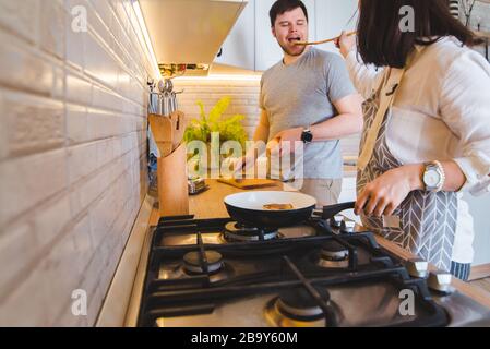 cucinare insieme in cucina. frittura pancake taglio di arancia. degustazione di cibo Foto Stock