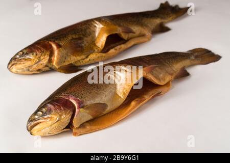 Pesce affumicato freddo. Trota fluviale, arcobaleno, oro, lago, freddo Karelian affumicato su sfondo bianco Foto Stock