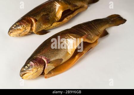 Pesce affumicato freddo. Trota fluviale, arcobaleno, oro, lago, freddo Karelian affumicato su sfondo bianco Foto Stock