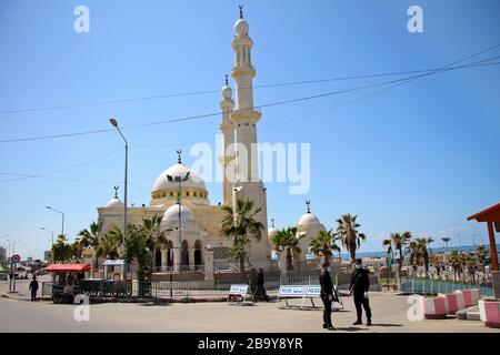 Gaza. 25 Marzo 2020. I membri delle forze di sicurezza palestinesi sono in guardia al di fuori di una moschea chiusa nella città di Gaza, il 25 marzo 2020. La Palestina di mercoledì ha dichiarato che due nuovi casi di COVID-19 sono risultati positivi, portando il numero totale degli infetti nei suoi territori a 62. Credit: Rizek Abdeljawad/Xinhua/Alamy Live News Foto Stock