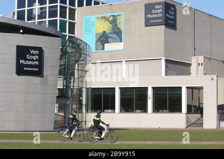 Amsterdam, Paesi Bassi. 25 Marzo 2020. Due poliziotti cavalcano biciclette pattuglie per la gente per praticare le distanze sociali e mantenere 1.5 metri pass sul Museo Van Gogh sono vicini al Museumplein il 25 marzo 2020 ad Amsterdam, Paesi Bassi. Il ministro olandese della giustizia e della sicurezza Ferdinand Grapperhaus ha ordinato nuove misure più severe per combattere la diffusione del coronavirus, nei parchi, nelle strade e negli spazi pubblici, la gente deve praticare il distanziamento sociale e mantenere 1.5 metri, questo per un gruppo di tre o più persone (che non sono familiari), Una multa di 400 euro sarà consegnato.(foto di Paulo Amori Foto Stock