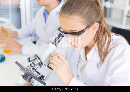 Scienziati maschili e femminili che lavorano in un laboratorio scientifico con varie attrezzature in laboratorio. Foto Stock