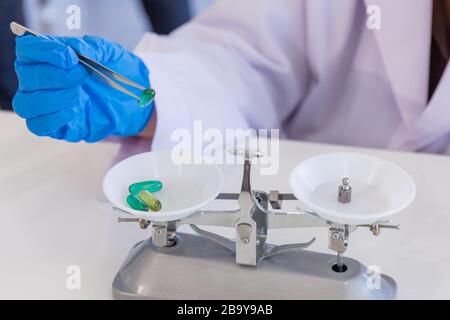 La scienziata asiatica femminile sta tenendo la medicina in un laboratorio di scienza. Sta facendo esperimenti e ricerche. Foto Stock
