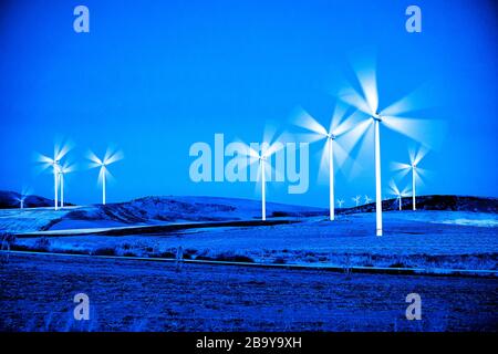 Il mulino a vento di turbine a vento la filatura veloce nel vento al tramonto o l'alba Foto Stock