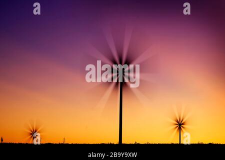 Il mulino a vento di turbine a vento la filatura veloce nel vento al tramonto o l'alba Foto Stock