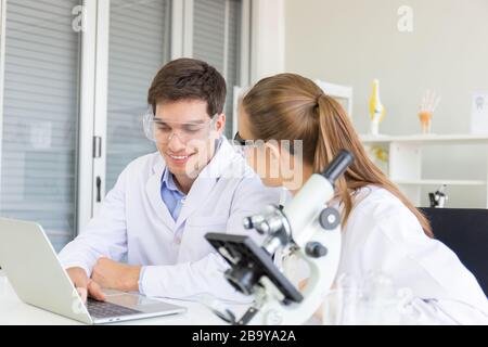 Il concetto di ricercatori sanitari, ricercatori che lavorano in laboratori di scienze biologiche, giovani ricercatori e supervisori maschili Foto Stock