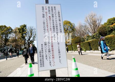 Tokyo, Giappone. 25 Marzo 2020. All'ingresso del Parco di Ueno è visibile un cartello per astenersi dalle tradizionali feste bevute di Hanami per prevenire la diffusione del COVID-19. Il governatore di Tokyo Yuriko Koike ha chiesto ai residenti, mercoledì, di astenersi da tutte le uscite non essenziali questo fine settimana, in mezzo a un aumento di 41 nuovi casi di infezioni da coronavirus segnalati a Tokyo solo mercoledì. Durante una conferenza stampa, Koike ha avvertito di bloccare la città se i casi di infezione da coronavirus continuano ad aumentare. Credit: Rodrigo Reyes Marin/ZUMA Wire/Alamy Live News Foto Stock