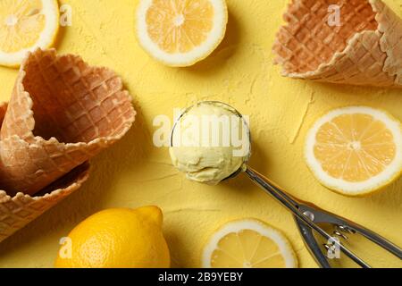 Gelato, cucchiaio, limone e waffle su sfondo giallo, vista dall'alto Foto Stock