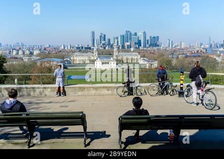 La gente si riunisce al punto di osservazione di Greenwich Park, un'area popolare per i residenti locali per intraprendere l'esercizio quotidiano di outing attualmente consentito dal governo britannico durante la pandemia di Covid-19. Le istruzioni per la popolazione sono di mantenere una distanza minima di due metri quando fuori in pubblico. Londra, Regno Unito. Foto Stock