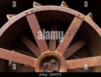 Ruota in acciaio arrugginita di vecchio trattore abbandonato, risalente agli inizi del 20 ° secolo. Foto Stock