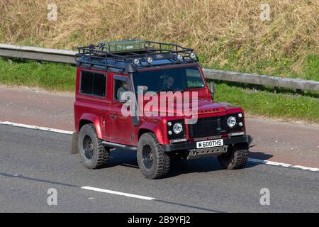 1998 90s Red Land Rover 90 Defender County SW TDI; veicoli in movimento, guida di veicoli, strade, motori, motori sull'autostrada M6 Foto Stock