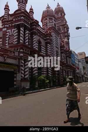 Colombo, provincia occidentale, Sri Lanka. 25 Marzo 2020. Un uomo cammina per una strada vuota dopo che le autorità hanno annunciato un coprifuoco nel paese come misura preventiva contro la diffusione del romanzo Coronavirus COVID-19, nella capitale Colombo 25 marzo 2020. Credit: Pradeep Dambarage/ZUMA Wire/Alamy Live News Foto Stock