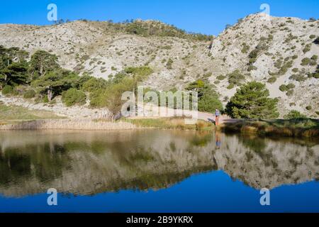 Escursionista riflettuto in piccolo stagno. Parco naturale ELS Ports. Catalogna. Spagna. Foto Stock