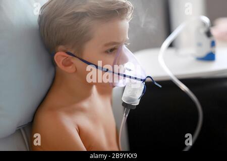 Un ragazzo trattato con maschere inalanti. Fumo a casa Foto Stock