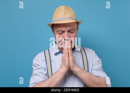 uomo anziano in estate cappello in preghiera. Spirituale e caratteristico. Foto Stock
