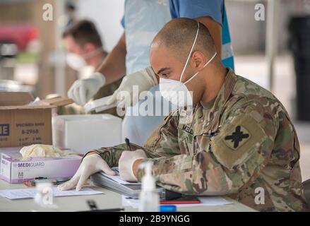 I membri della Guardia Nazionale della Louisiana elaborano tamponi nasali da pazienti per il COVID-19, coronavirus presso un Centro Mobile Testing situato a Louis Armstrong Park il 24 marzo 2020 a New Orleans, Louisiana. Il sito di test è uno dei tre nelle parrocchie di New Orleans e Jefferson e sarà presto aperto al pubblico. Foto Stock