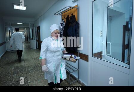 Infermiere in un camice da laboratorio che cammina attraverso la hall di un vassoio per il trasporto dell'ospedale con farmaci per i pazienti. 2 febbraio 2020. Kiev, Ucraina Foto Stock