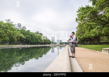 Houston, Texas, Stati Uniti. 25 Marzo 2020. DUY LONG si sta godendo la sua mattina con la sua figlia di 13 mesi il primo giorno dell'ordine di soggiorno a casa. Un ordine di soggiorno a casa è stato emesso martedì per i residenti della contea di Houston e Harris per contribuire a combattere la diffusione del COVID-19. Il nuovo coronavirus causa sintomi lievi o moderati per la maggior parte delle persone. Tuttavia, per alcuni, soprattutto gli adulti più anziani e le persone con problemi di salute esistenti, può causare malattie più gravi o la morte. Credit: Lynn Pennington/ZUMA Wire/Alamy Live News Foto Stock