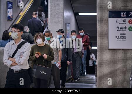 Persone che indossano maschere facciali come misura preventiva durante la pandemia del virus della corona. Hong Kong ha finora riportato un totale di 410 casi confermati di coronavirus COVID-19 e 4 persone sono morte di conseguenza. Foto Stock