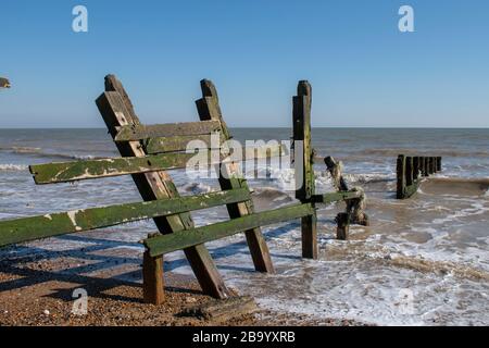 Vecchia difesa del mare in legno danneggiata dalle tempeste invernali su Climping Beach Inghilterra. Foto Stock