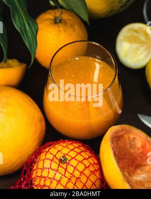 Un bicchiere di succo di frutta appena spremuto e arancia fresca al limone e pompelmo Foto Stock