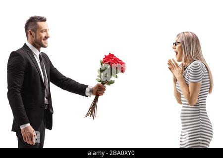 Uomo che dà un mazzo di rose rosse ad una donna sorpresa isolato su sfondo bianco Foto Stock