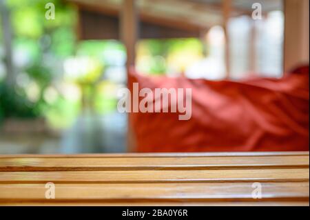 Piano in legno con cuscino rosso sfocato sullo sfondo del soggiorno Foto Stock