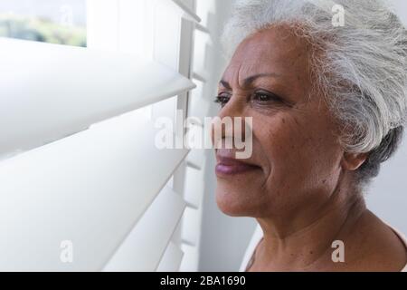 Vista laterale di una donna afroamericana che guarda all'esterno Foto Stock