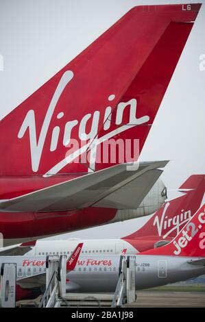 Glasgow, Regno Unito. 25 Marzo 2020. Nella foto: Velivolo Virgin Atlantic (Boeing 747-400 serie - chiamato Ruby Tuesday, registrato G-VXLG) e un Airbus A330-200 - chiamato Honkytonk Woman, registrato G-VMIK) stand a terra sul asfalto da parte del gancio Logan Air. Credit: Colin Fisher/Alamy Live News Foto Stock