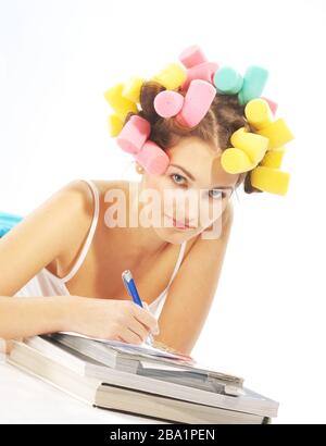 Una donna che scrive con i curlers sulla sua testa Foto Stock