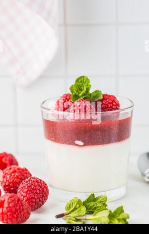 Panna cotta italiana in vetro con lamponi. Foto Stock